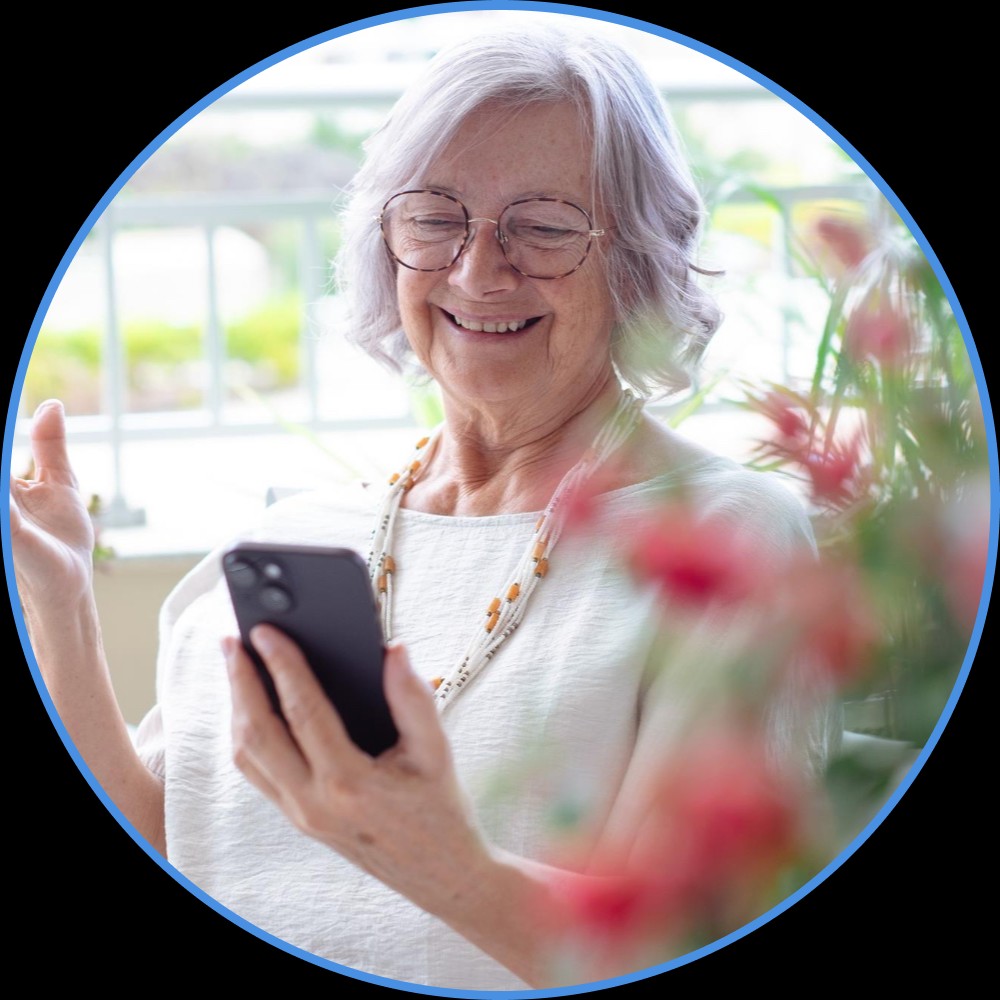 Großmutter schaut sich lächelnd Eventfotos in der lifemoments App an