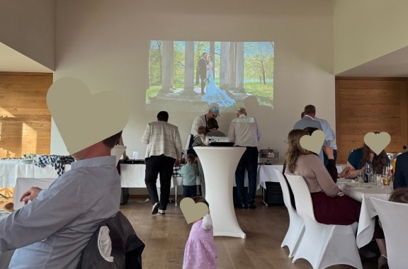 Hochzeitsfeier mit live an die Wand projizierten Fotos des Brautpaars